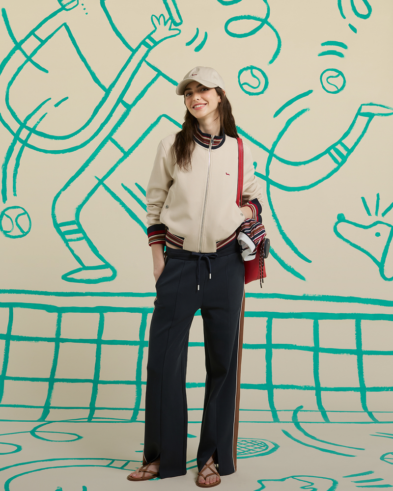 Donna con bomber giacca crema con bordini a righe e pantaloni blu navy
