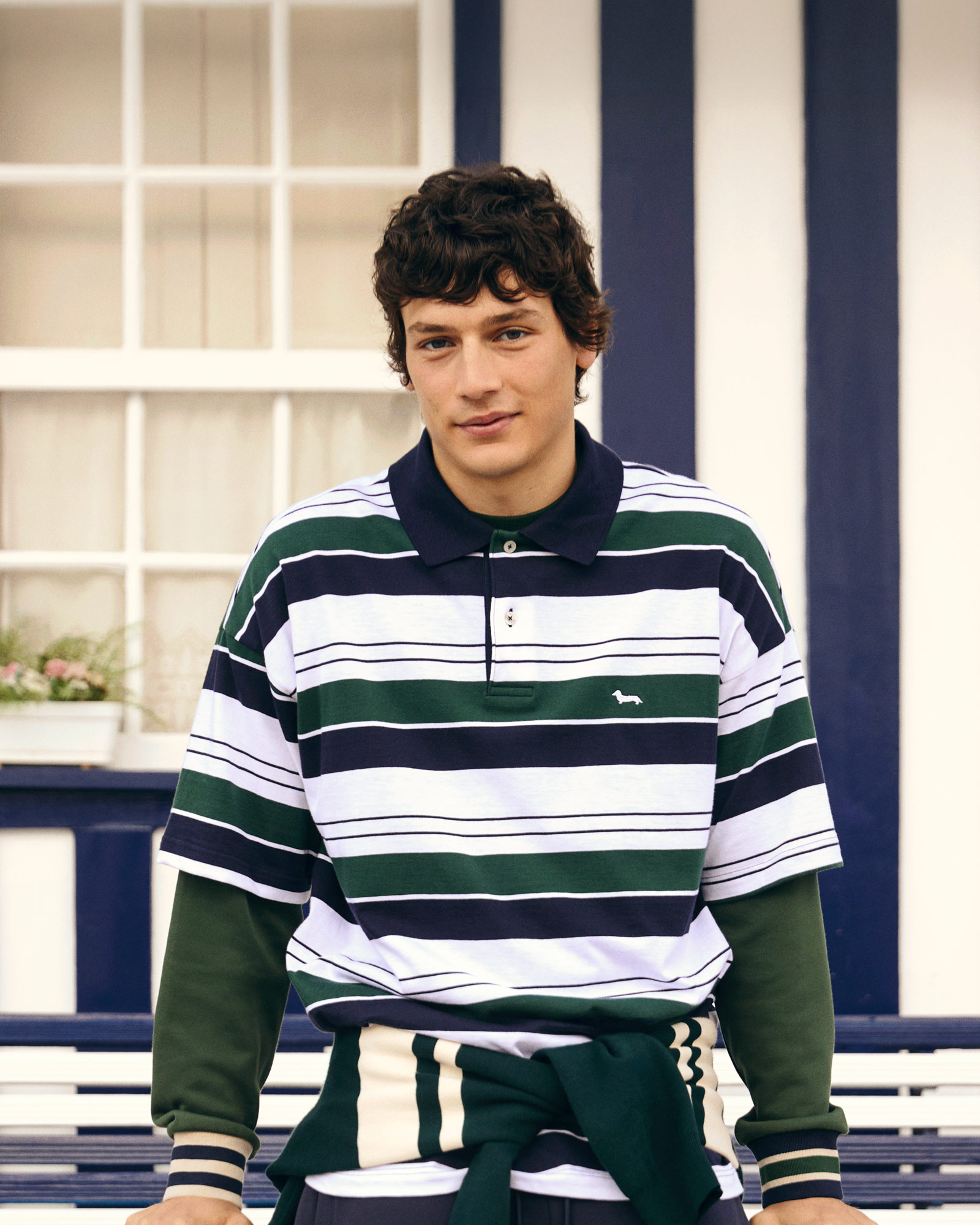 Uomo con polo rugby a righe verdi, blu e bianche