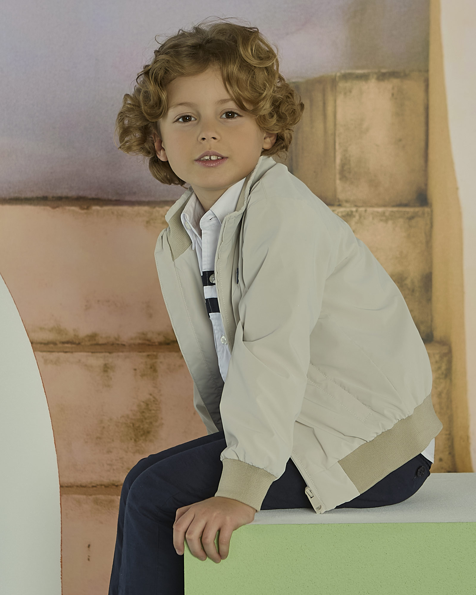 Boy wearing beige jacket and blue pants