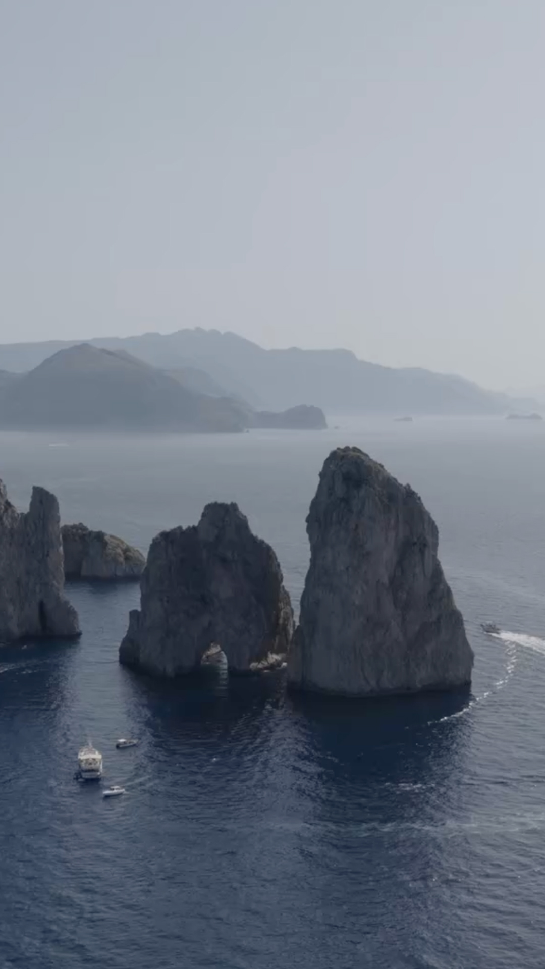 Capri's Faraglioni rocks with moving boats