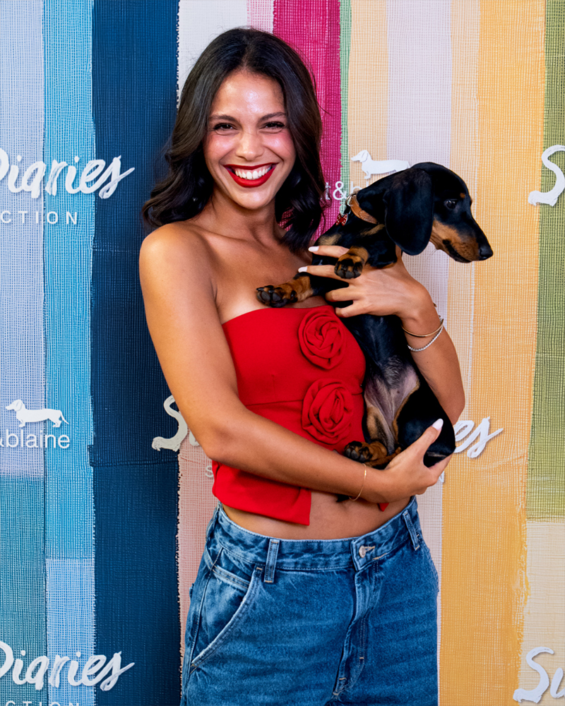 Woman in red top with dog at Summer Diaries event.