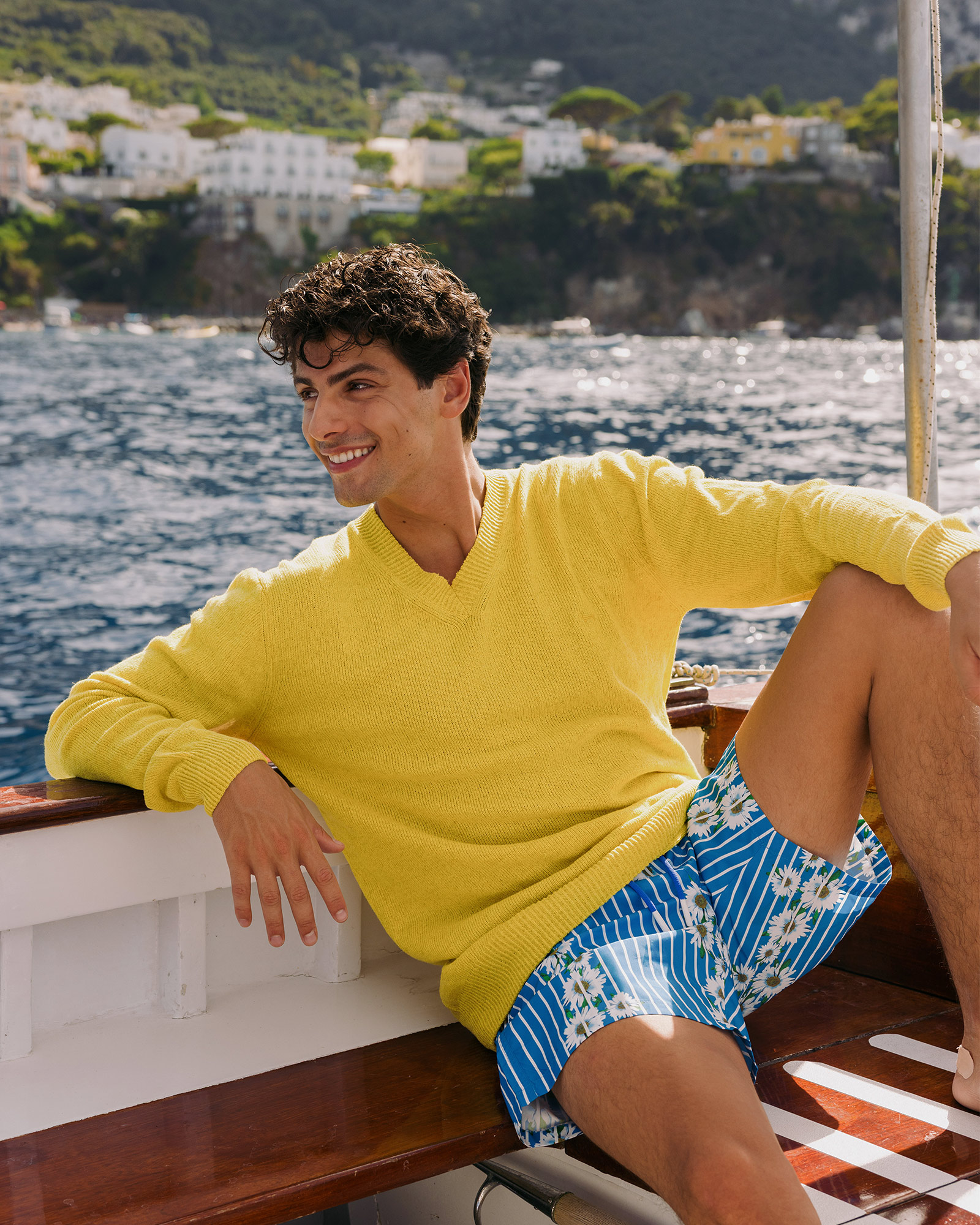 Man in yellow sweater sitting on a boat