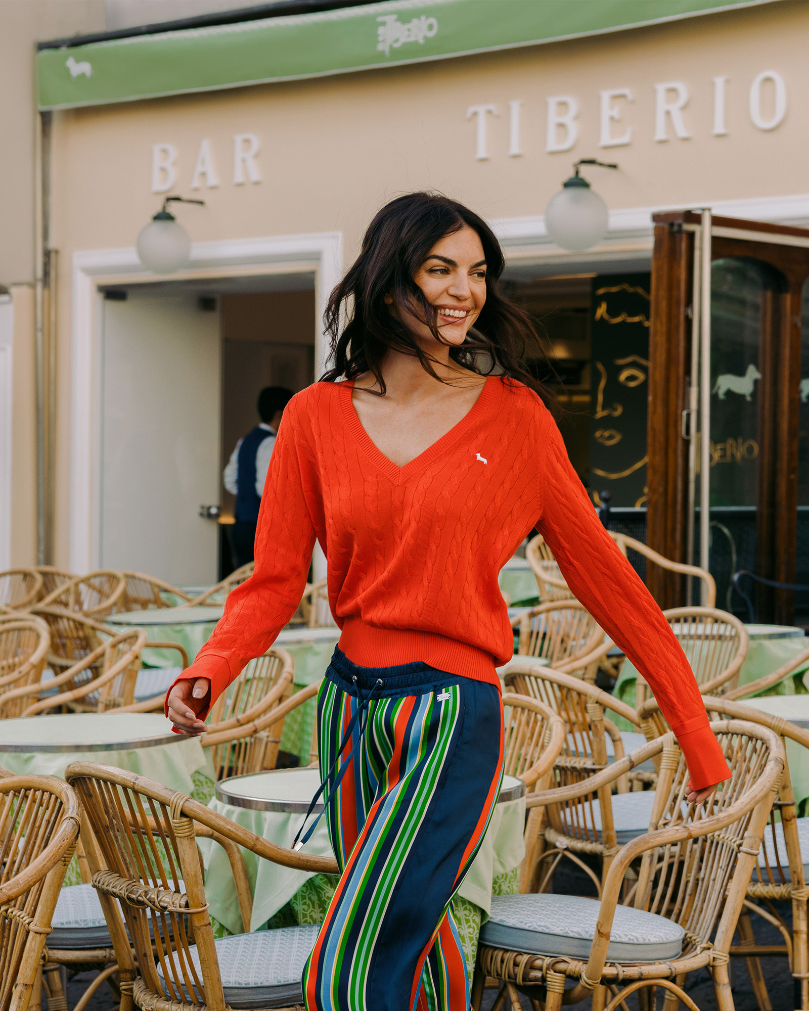 Woman in red sweater smiling in front of Bar Tiberio