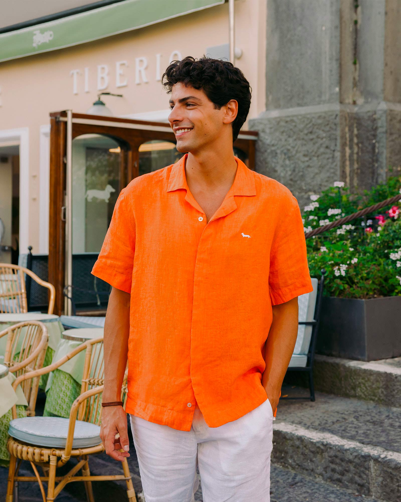 Man in orange shirt outside a street café