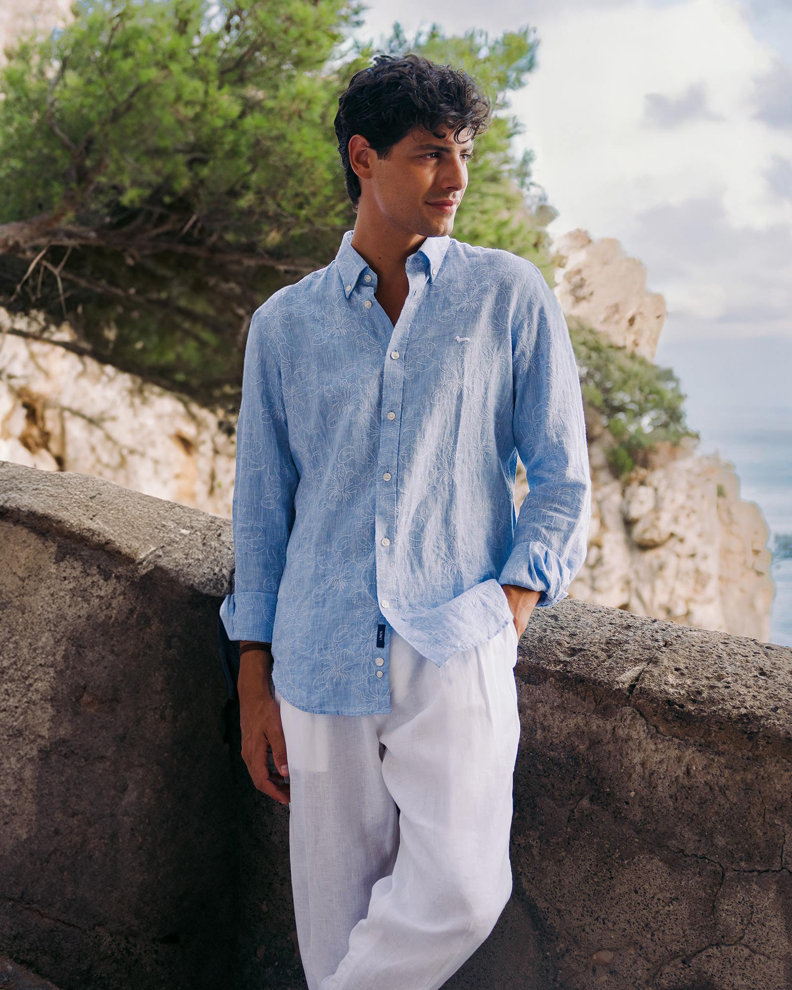 Man in light blue linen shirt by the sea