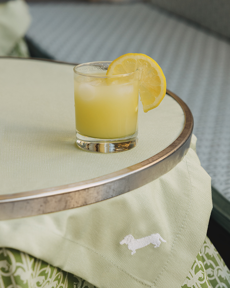 Cocktail glass with lemon on Harmont & Blaine table.