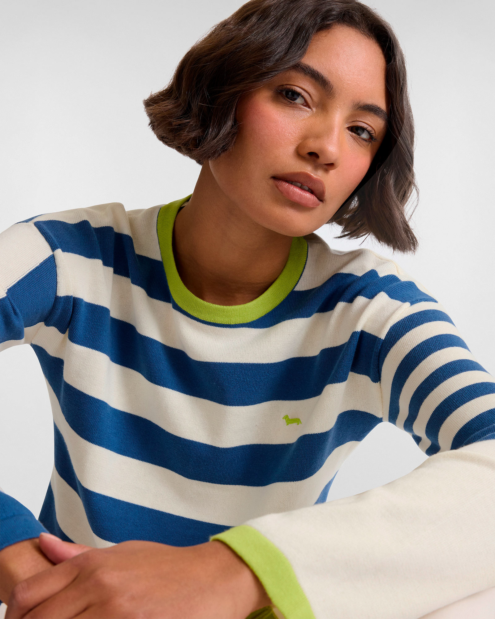 Mujer con jersey de rayas azules y blancas con detalles verdes
