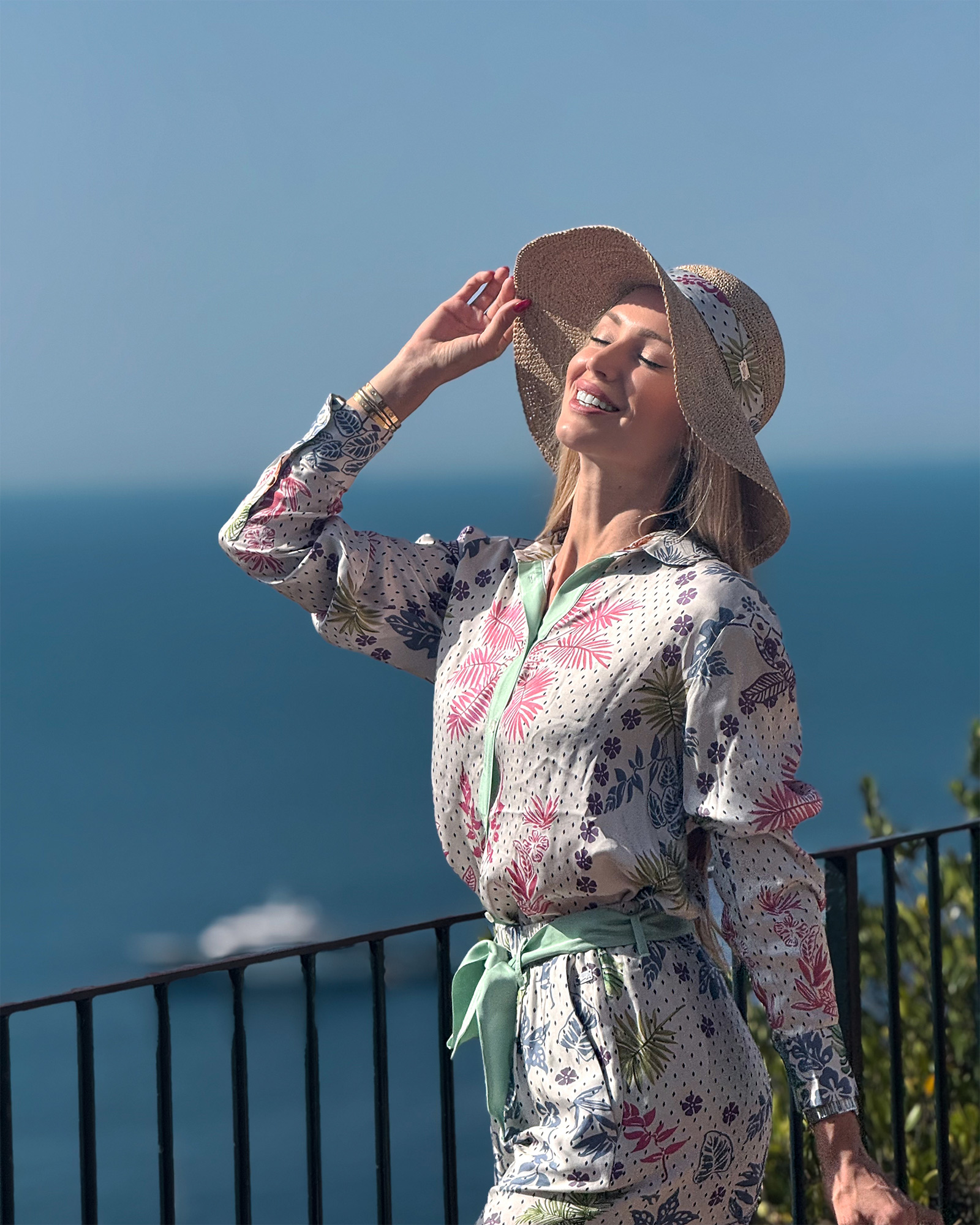 Donna sorridente con cappello e abito floreale